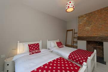 An original fireplace and exposed brick add character and a hint of history to this bedroom