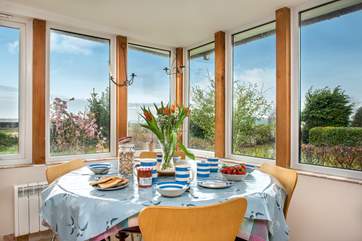 The dining-table takes pride of place looking out at the garden and the views beyond.