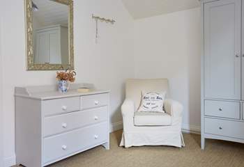 A cosy reading chair in the corner of bedroom three.
