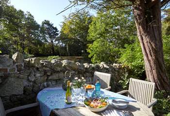 Al fresco dining on one of the sunny terraces in the front garden at Sunset Cottage.