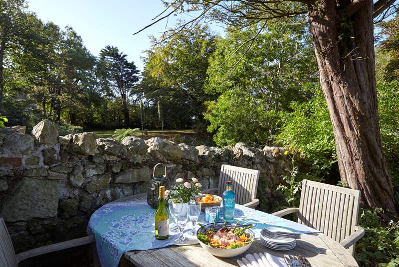 Al fresco dining on one of the sunny terraces in the front garden at Sunset Cottage.