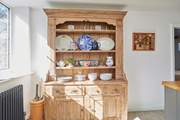 The oak sideboard in the kitchen with decorative but useful dishware.