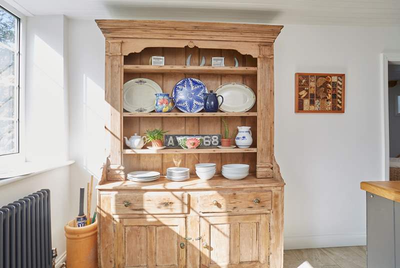 The oak sideboard in the kitchen with decorative but useful dishware.