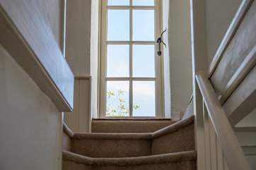 The top of the stairs links you to all first floor rooms and magically opens onto the roof patio.