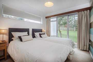 Bedroom 3 also offers a super-king size bed which can be configured as two single beds. You also have direct access to the lawn area via the patio door.