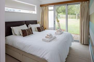 Bedroom three also offers a super-king size bed which can be configured as two single beds. You also have direct access to the lawn area via the patio door.