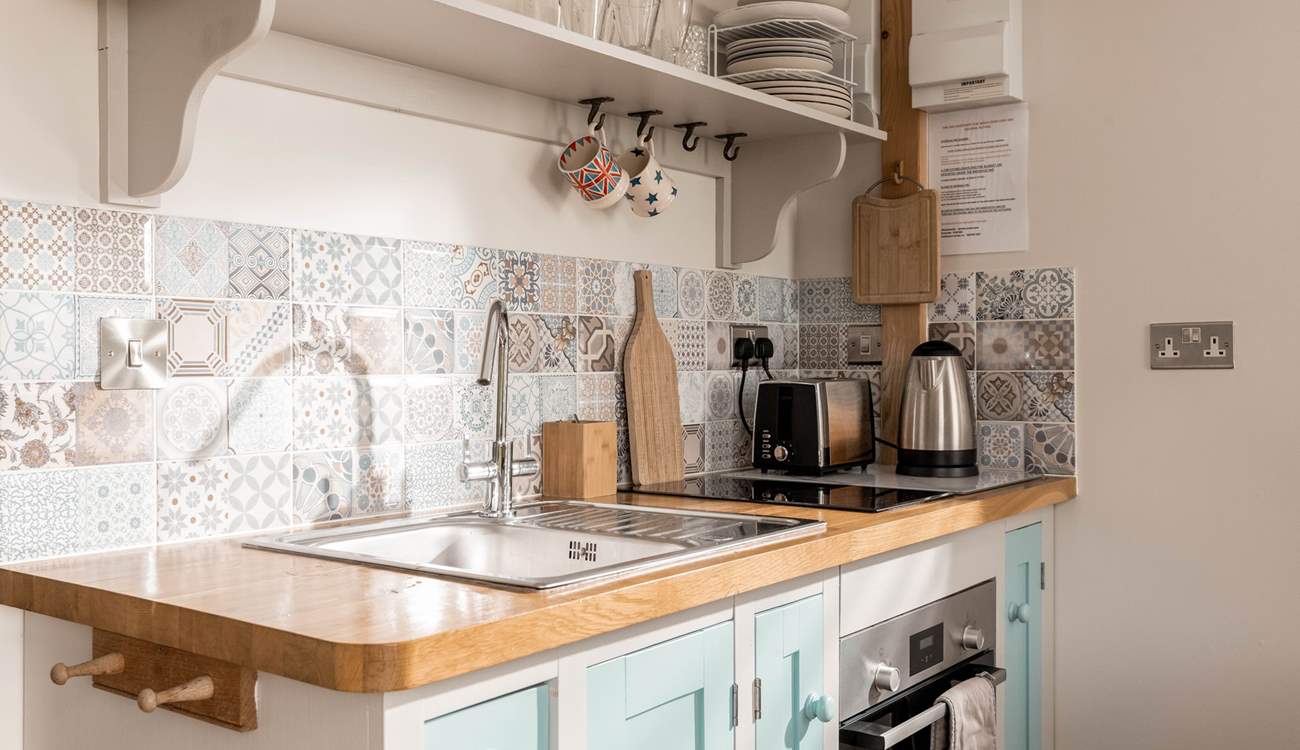 The sweetest kitchenette, with an array of beautiful tiles. 
