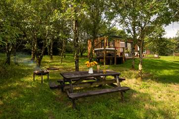 With a picnic table set under the trees, a firepit, hot tub and sun loungers, this is such a special setting.
