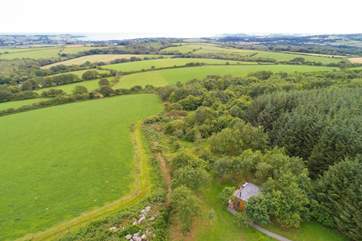 Tucked into woodland with views over to the sea in the distance.