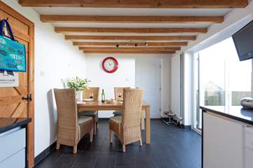 The dining-area has doors that lead out to the enclosed garden with its decked terrace and sea views.
