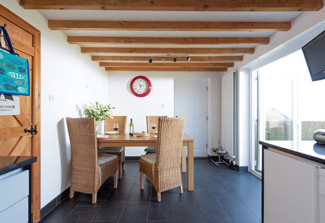 The dining-area has doors that lead out to the enclosed garden with its decked terrace and sea views.