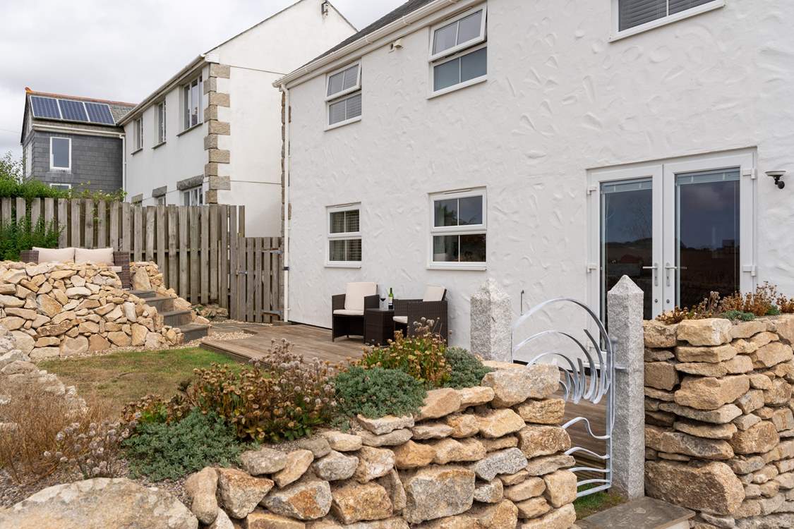 The gorgeous back garden has an elevated terrace, perfect for taking in the sea views.