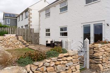 The gorgeous back garden has an elevated terrace, perfect for taking in the sea views.