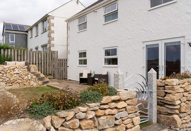 The gorgeous back garden has an elevated terrace, perfect for taking in the sea views. 