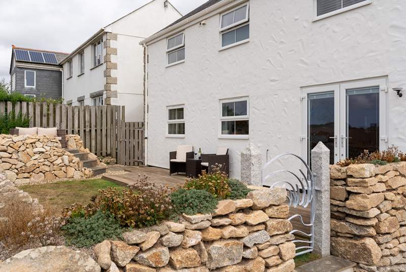 The gorgeous back garden has an elevated terrace, perfect for taking in the sea views. 