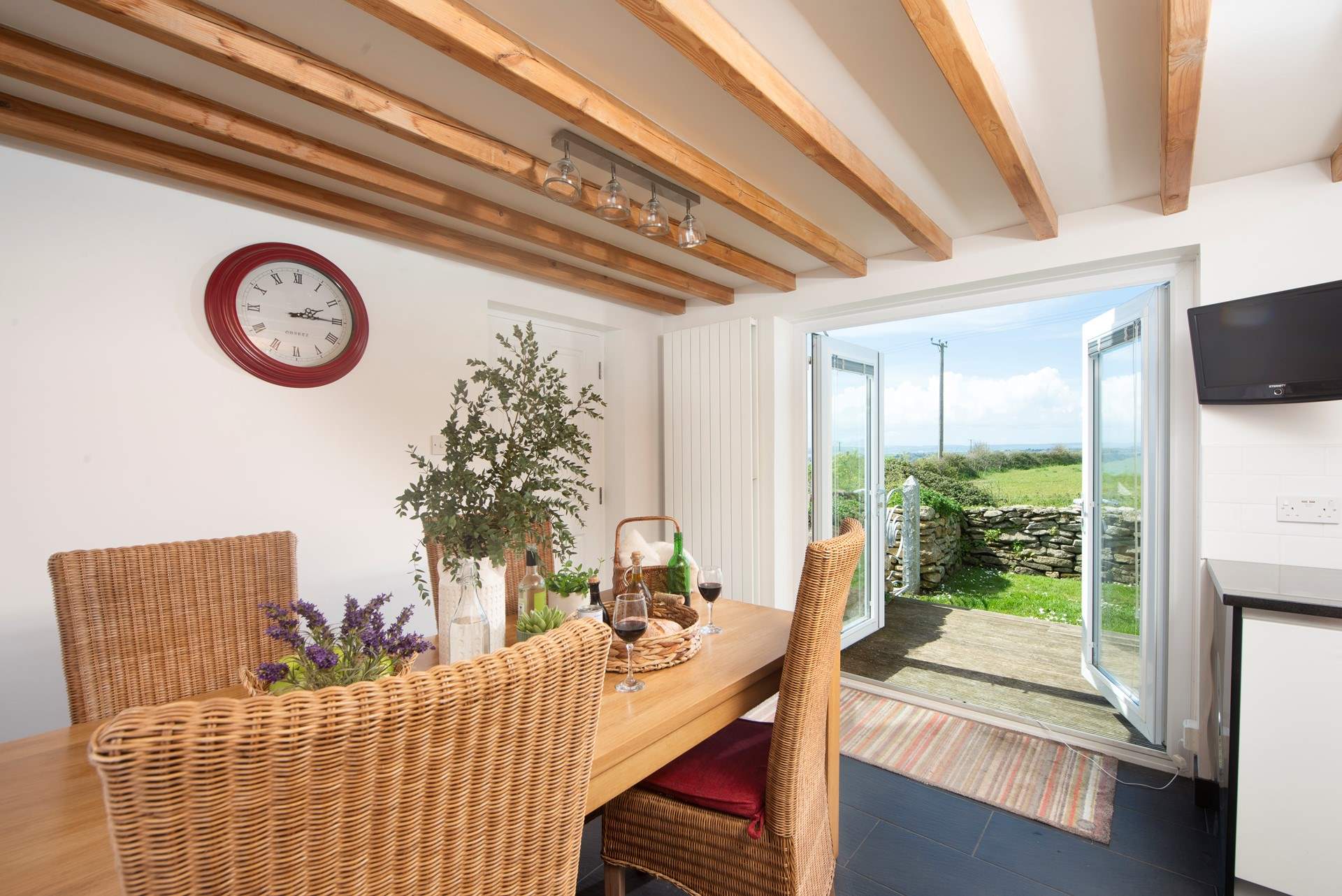 The dining-area has doors that lead out to the enclosed garden with its decked terrace and sea views.