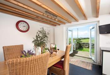 The dining-area has doors that lead out to the enclosed garden with its decked terrace and sea views.