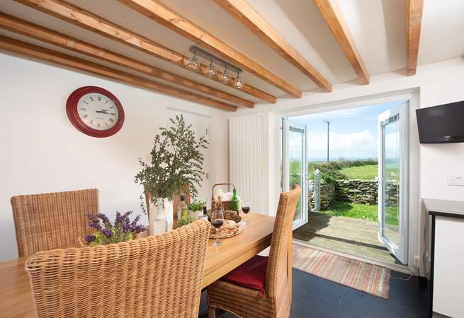 The dining-area has doors that lead out to the enclosed garden with its decked terrace and sea views.