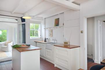 The sun-room, rear left, the kitchen-area, the hallway and the sitting-room to the right.