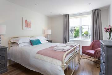 That master bedroom is beautifully styled in relaxing pale pinks and soft creams.