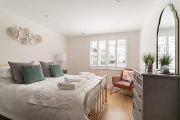 That master bedroom is beautifully styled in relaxing pale pinks and soft creams.