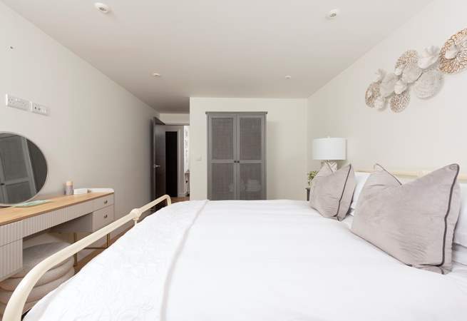 The main bedroom is beautifully styled in relaxing pale pinks and soft cream hues.