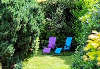 The garden extends behind the big fir trees.