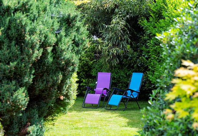 The garden extends behind the big fir trees.