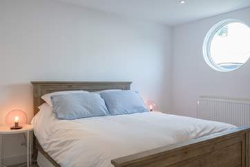 Natural daylight streams through the porthole of the second double bedroom.