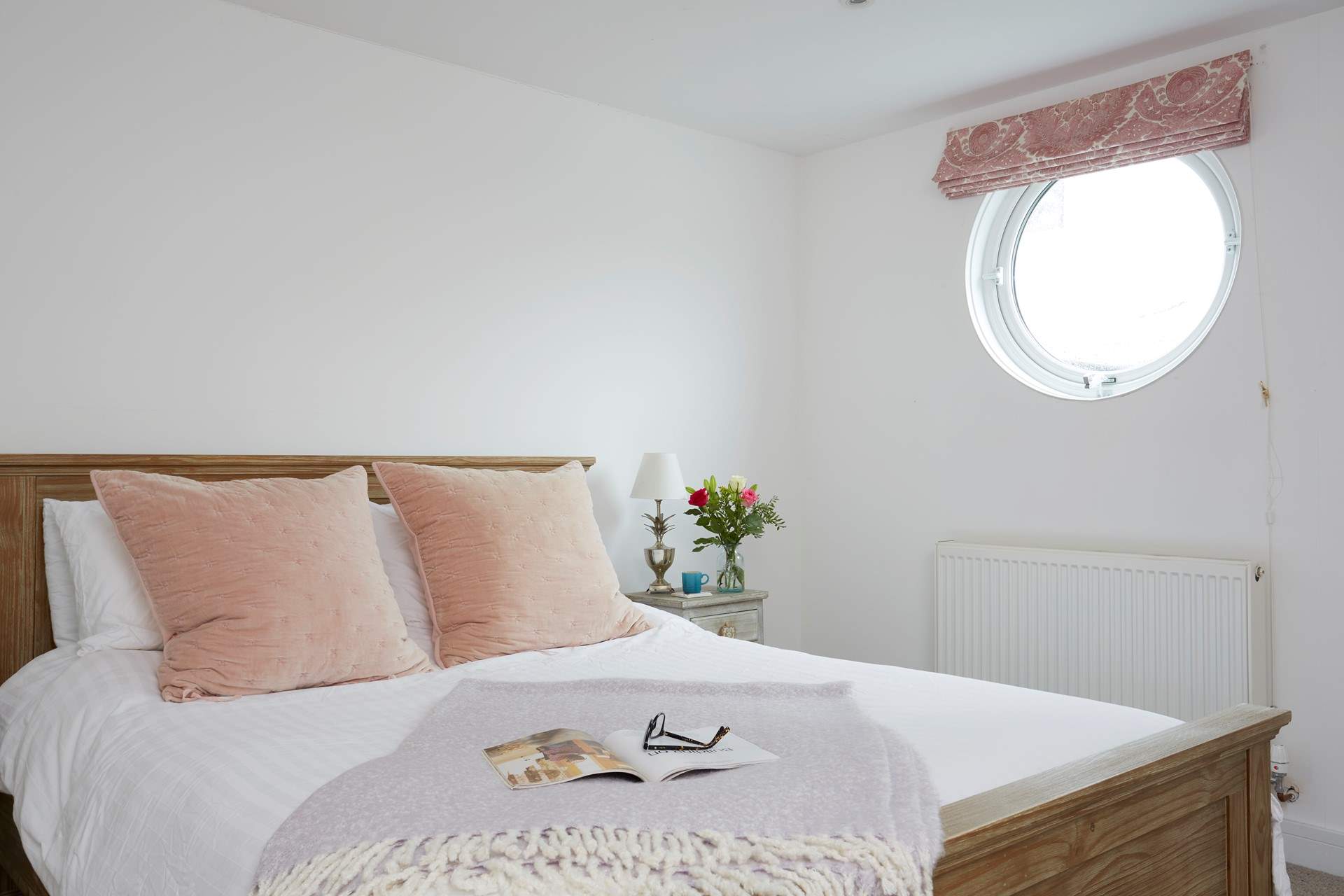 Natural daylight streams through the porthole of the double bedroom.