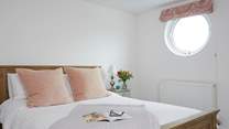 Natural daylight streams through the porthole of the double bedroom.