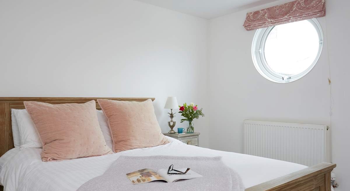 Natural daylight streams through the porthole of the double bedroom.