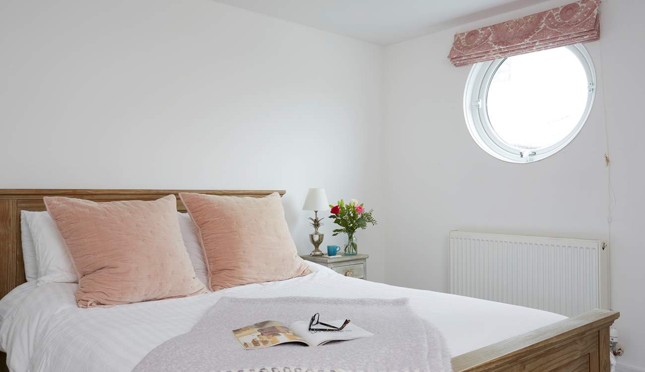Natural daylight streams through the porthole of the double bedroom.