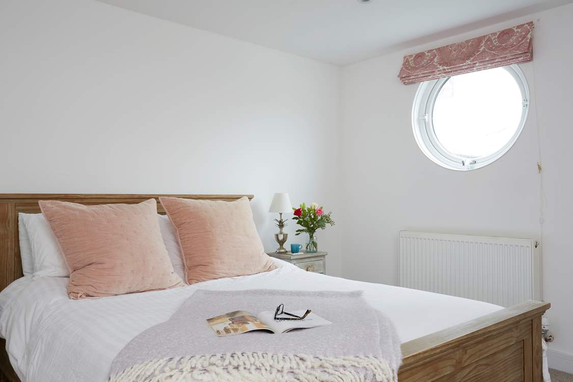 Natural daylight streams through the porthole of the double bedroom.