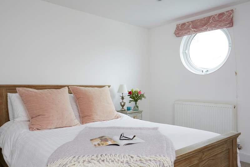 Natural daylight streams through the porthole of the double bedroom.