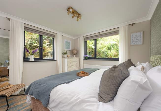 Bedroom 2 is a sleek space embraced by lush garden banks.