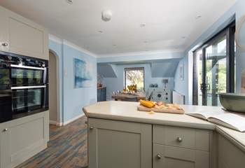 The modern kitchen leads to the dining area with doors to the conservatory.