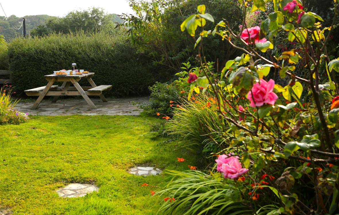 The pretty cottage garden sits at the back of the cottage, accessed up some stone steps