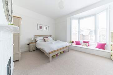 The light-filled master bedroom has a wide bay window with seating.