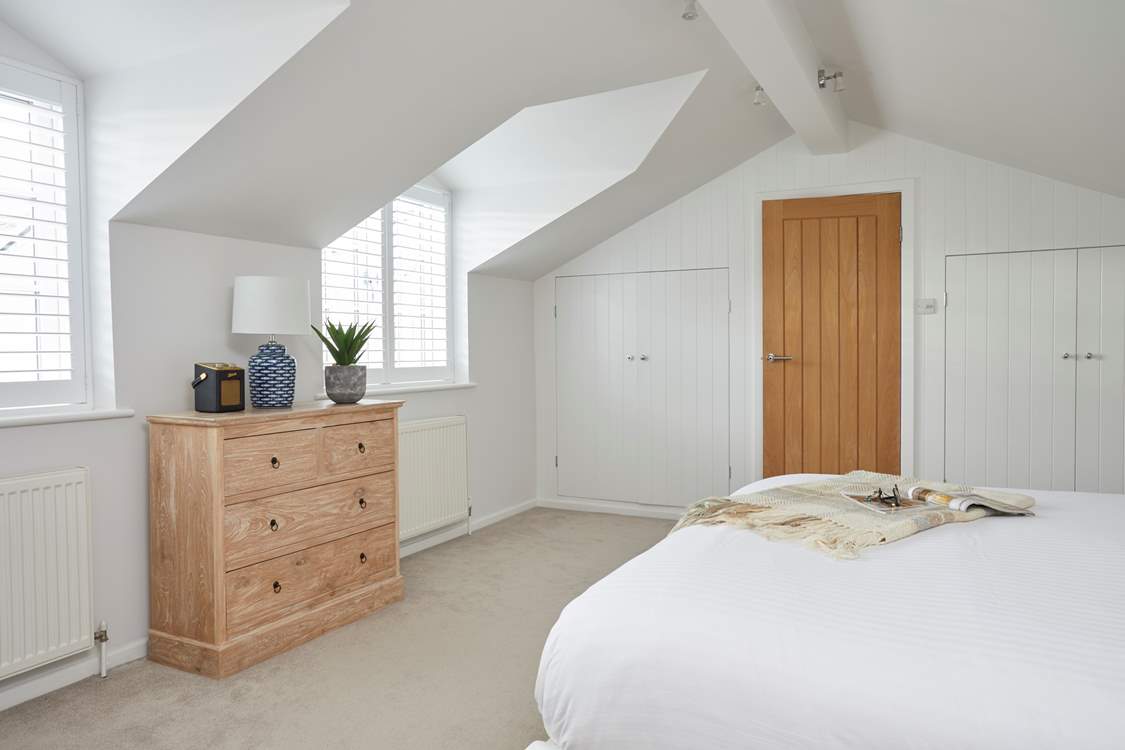 The main bedroom on the first floor with door leading out to the hallway.