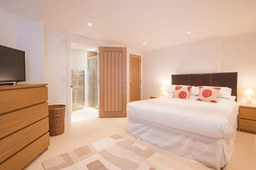 En suite double bedroom with patio doors to a small courtyard, with external steps leading to the parking area.