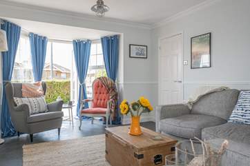 The pretty living-room has doors that open up to a lovely patio-area at the front of the property.