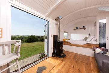 The comfy king-size bed is at the far end of the hut.