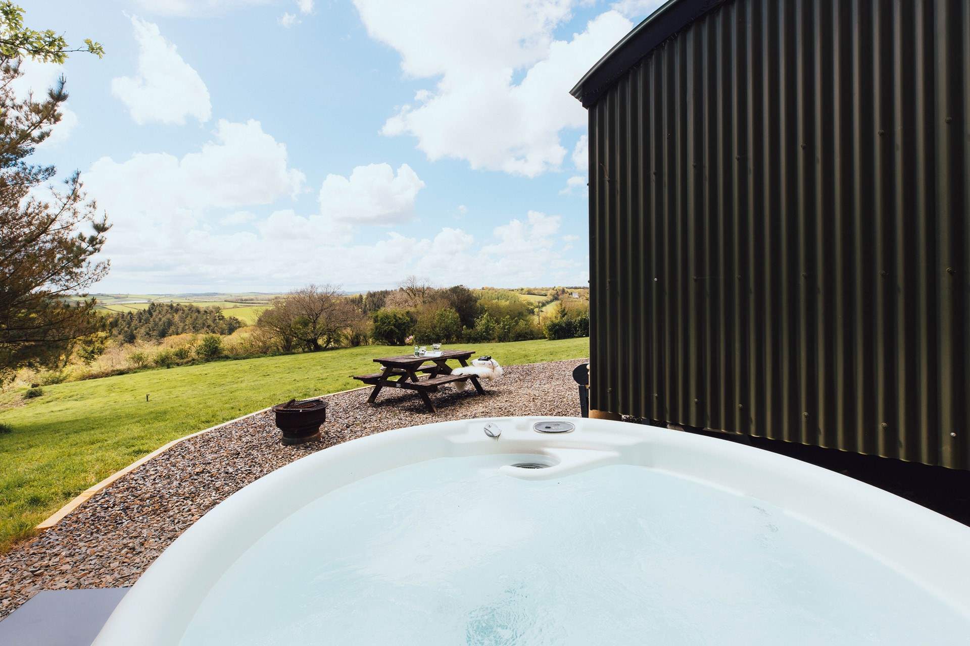 Slip into the bubbling hot tub and enjoy stunning views of rolling countryside