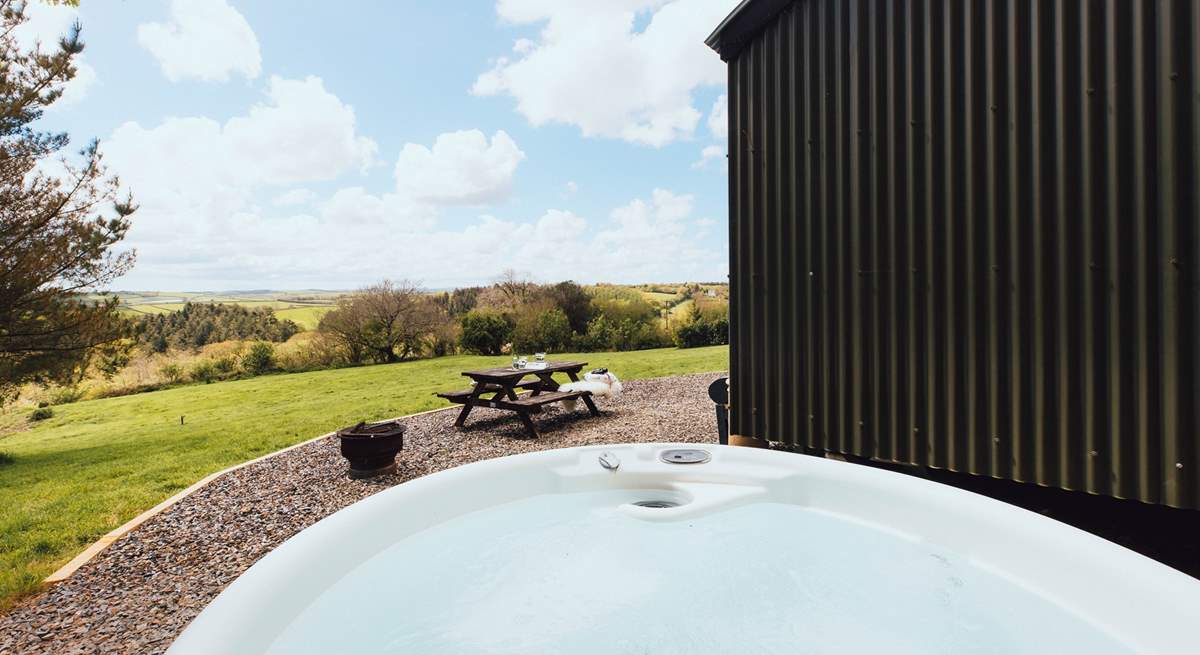 Slip into the bubbling hot tub and enjoy stunning views of rolling countryside