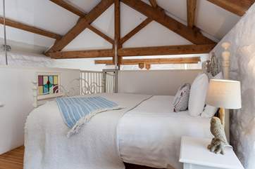 The bedroom retains much of the character of the original barn, with lovely stone walls and exposed beams.