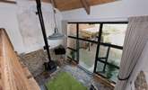 Looking down from the mezzanine level to the open plan living space and out into the courtyard. - Thumbnail Image