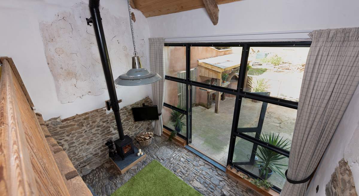 Looking down from the mezzanine level to the open plan living space and out into the courtyard.