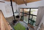 Looking down from the mezzanine level to the open plan living space and out into the courtyard.
