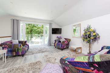 The first floor sitting-room leads out to a super balcony which overlooks the terrace and hot tub.